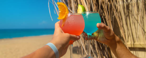 istock Woman on the beach holding a cocktail in her hands. Selective focus. 1364241740