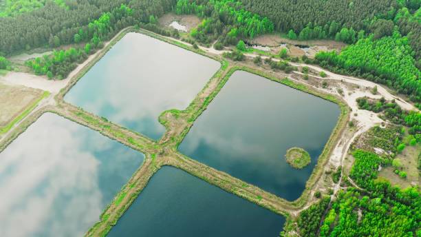 vue aérienne bassins de rétention, étang humide, bassin de rétention ou étang de gestion des eaux pluviales, est un étang artificiel avec de la végétation autour du périmètre, et comprend une piscine permanente d’eau dans sa conception 4k - retention pond photos et images de collection