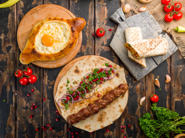 istock ajara Khachapuri with cheese, egg and butter, lula kebab with lamb, shawarma with chicken, georgian kitchen on wooden table top view 1364246534