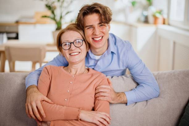 istock Beautiful middle aged mother and young man embracing 1364248237