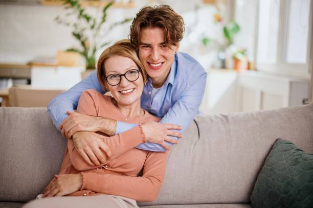 istock Beautiful middle aged mother and young man embracing 1364248238