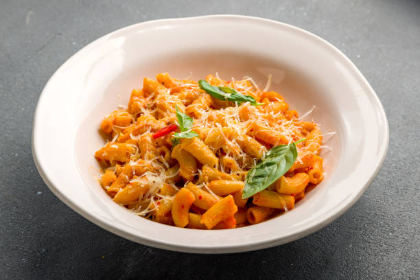 istock Pasta Penne arabiata with tomato sauce on grey concrete table 1364248683