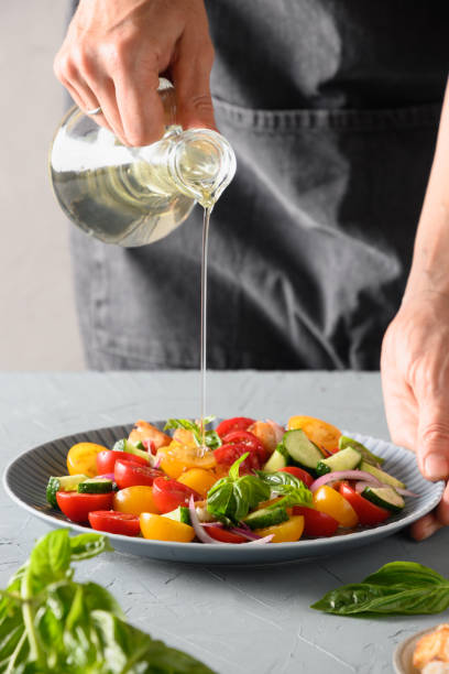 istock Woman cooking Panzanella salad from fresh vegetables. 1364249599