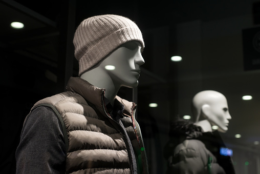 Closeup of mannequin with woolen hat and winter coat in a fashion store showroom for men
