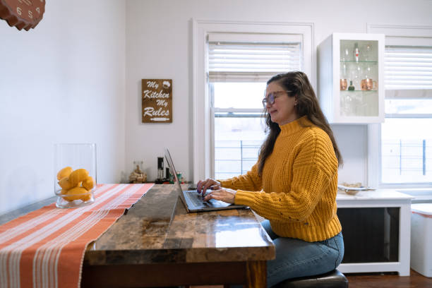 istock Mature latin woman using computer at home 1364251247