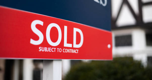 estate agent sold sign close up of sold sign in front of house - narrow depth of field selling stock pictures, royalty-free photos & images