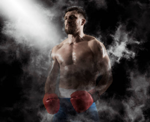 Man boxer in red gloves on smoke background