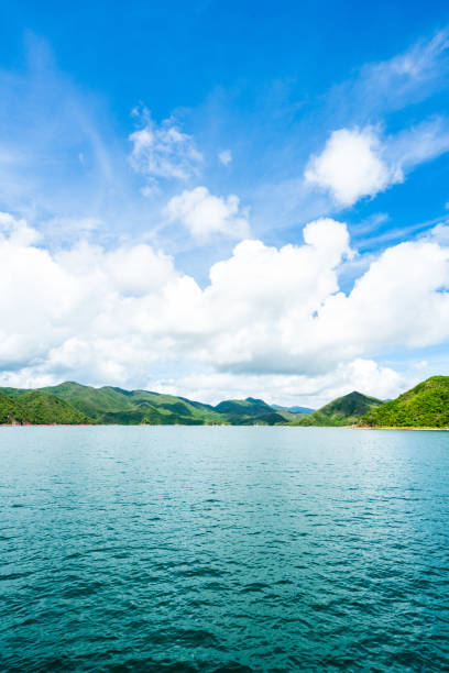 île verte sous le ciel bleu par temps ensoleillé - hong kong sea sky cloud photos et images de collection