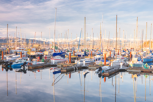 13 April 2018: Husavik, Iceland. The harbour at Husavik in Northern Iceland, with whale-watching vessels reflected in the calm water.