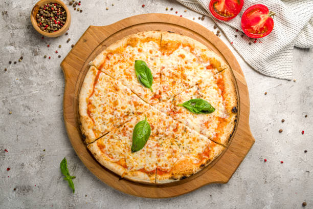 pizza italiana margherita con queso, salsa de tomate y albahaca sobre vista de mesa de hormigón gris - cheese pizza fotografías e imágenes de stock