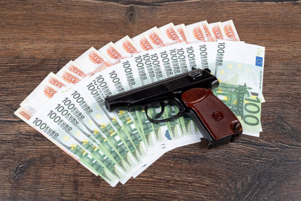 마카로프 권총은 유로와 루블 지폐에 놓여 있습니다. - currency crime gun conflict 뉴스 사진 이미지