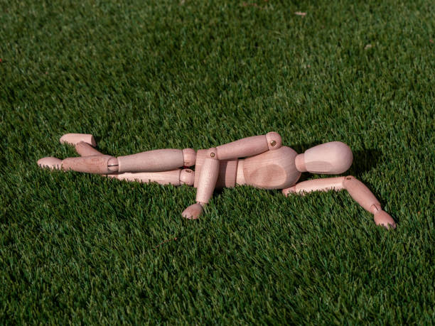 istock Wooden doll lying on the grass relaxed sunbathing 1364268944