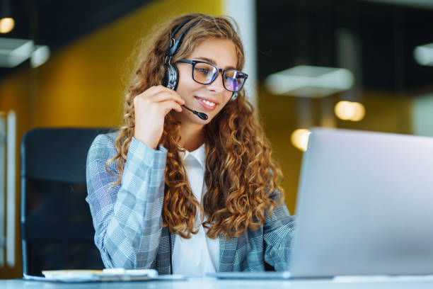istock Call center agent with headset working on support hotline in modern office. 1364269955