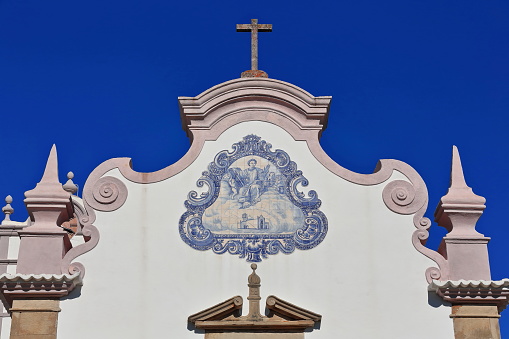 W.facing front facade-Sao Lourenço Church-Igreja Matriz built at XVII century's end in Baroque style-second tier with azulejo tile on frontispiece. Almancil parish-Loulé municipality-Algarve-Portugal.