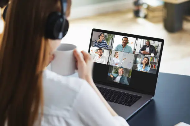 Photo of Online learning or business meeting, remote work using a laptop computer via video call. Successful caucasian freelancer woman takes part in video conference with employees. Distant working, online learning at home
