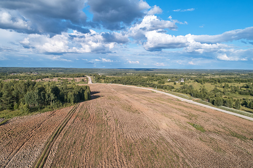 Aerial photography with a drone. Village with green forest, road and field.