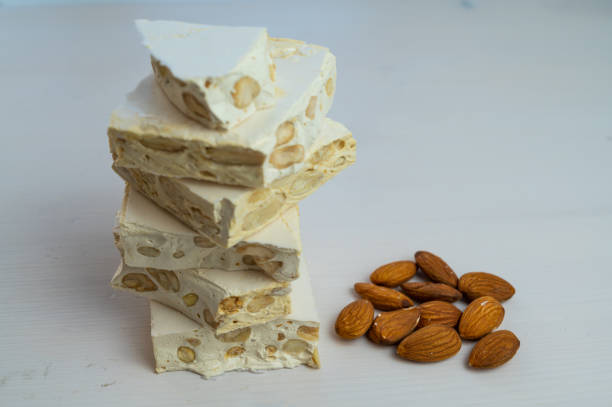Hard nougat, with almonds next to it. stock photo