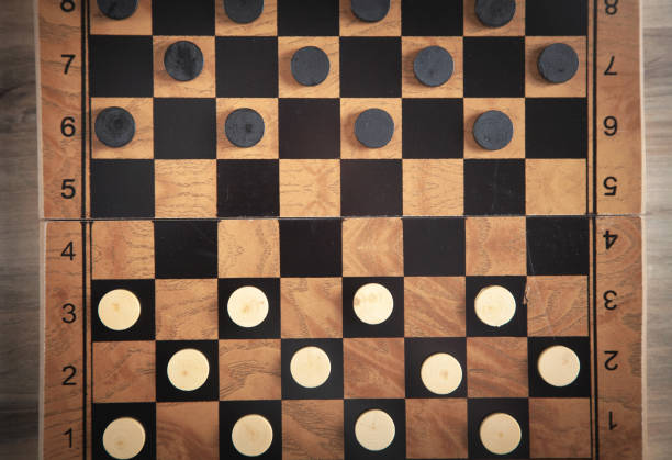 istock Checkers game on checkerboard in wooden background. 1364279256