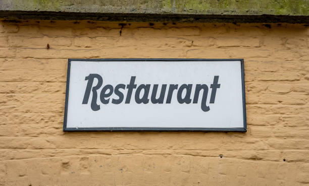 istock Restaurant sign on an old building with beige coloured facade 1364280355