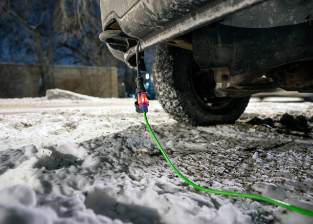Extension cord plugged into vehicle in winter stock photo