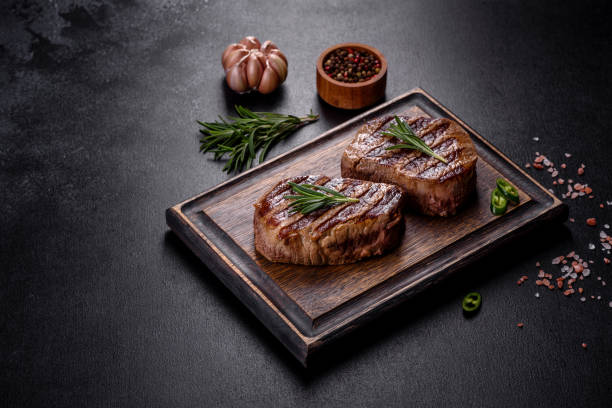 istock Fresh juicy delicious beef steak on a dark background 1364280778