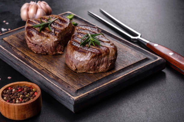 istock Fresh juicy delicious beef steak on a dark background 1364280790