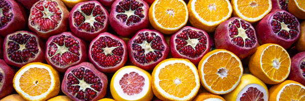 Pomegranates, oranges and grapefruits on counter Cutted pomegranates, oranges and grapefruits on counter with street fresh juice. Red and orange fruits, front view. Real showcase with street food in Istanbul, Turkey. Web banner juice bar stock pictures, royalty-free photos & images