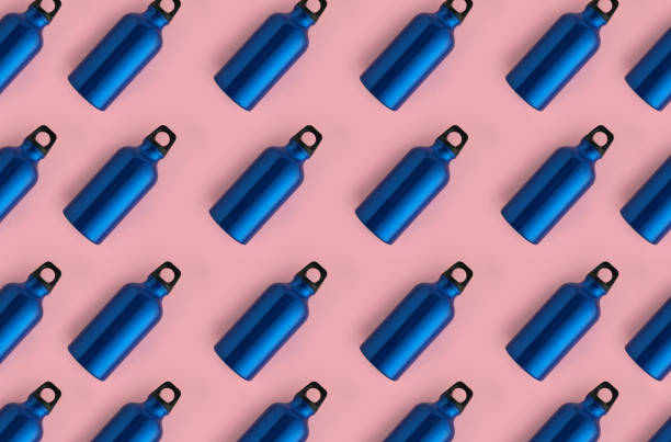 Seamless pattern of blue stainless steel water bottles on pink background abstract Seamless pattern of blue steel water bottles on pink background blue reusable water bottle stock pictures, royalty-free photos & images