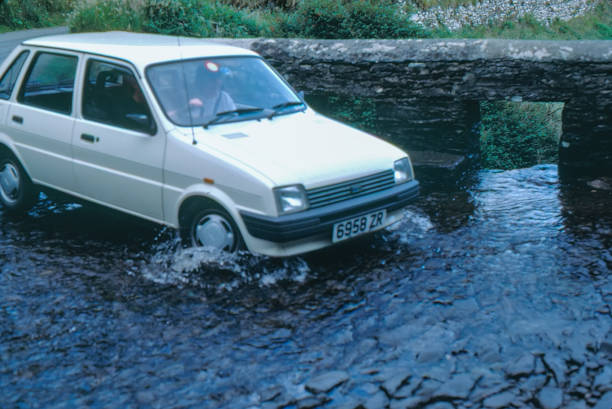 A car is passing a country road which is covered by the mountain stream, Slea Head, County Kerry, Ireland.