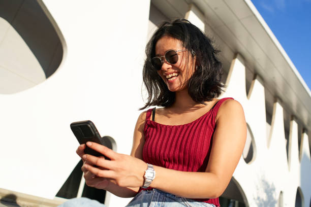 istock Woman Smiling and Using Mobile Phone Outdoors. Happy People smartphone. 1364288929