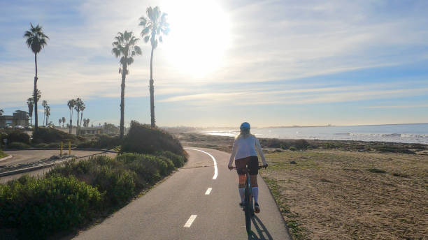 istock Female mountain biker follows pedestrian pathway along ocean 1364289182