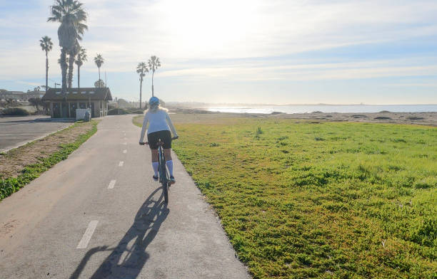 istock Female mountain biker follows pedestrian pathway along ocean 1364289244