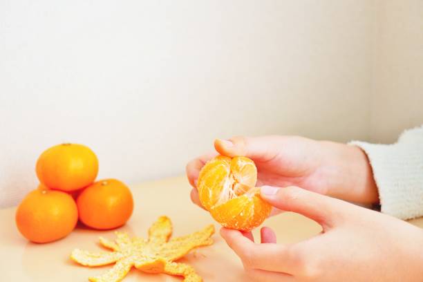 istock A woman's hand separating the peeled oranges 1364289248