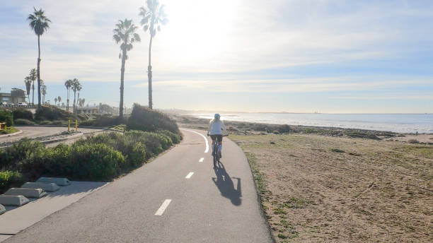 istock Female mountain biker follows pedestrian pathway along ocean 1364289252