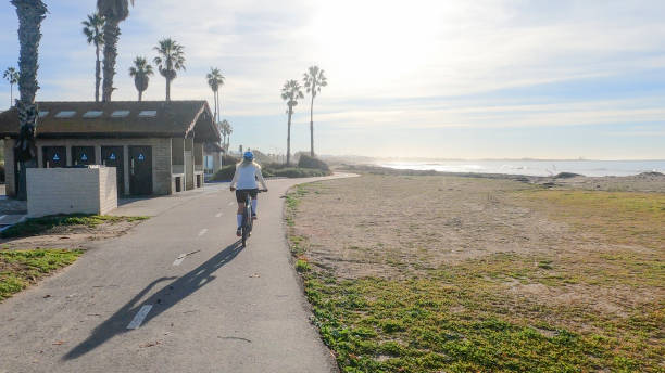 istock Female mountain biker follows pedestrian pathway along ocean 1364289258