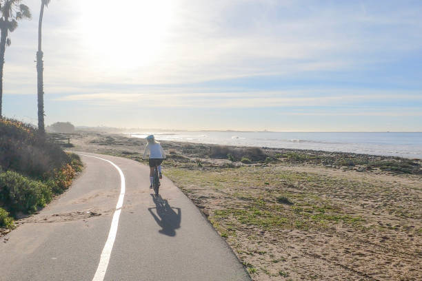 istock Female mountain biker follows pedestrian pathway along ocean 1364289269