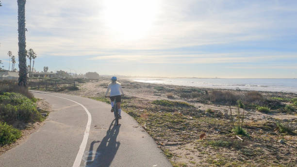 istock Female mountain biker follows pedestrian pathway along ocean 1364289285