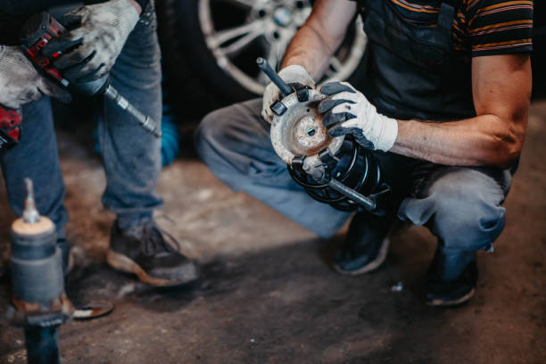 istock car suspension repair, shock absorber spring replacement in car service. 1364289337