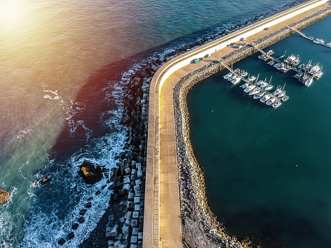 Aerial view of jetty or harbor breakwater on sea. Concept of travel.