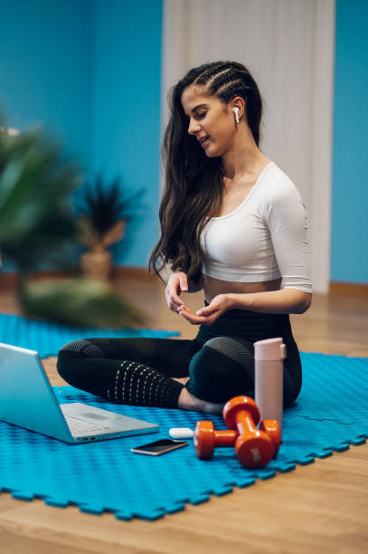 istock Attractive fitness instructor coaching an online class while using a laptop 1364296971
