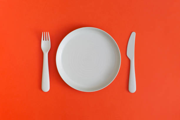istock Plate with fork and spoon on a red background. Top view. Flat lay. 1364297766