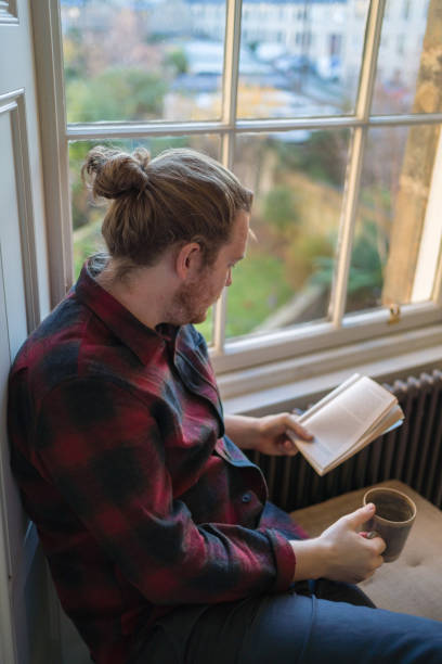 istock Young man reads book and enjoys a tea 1364298029