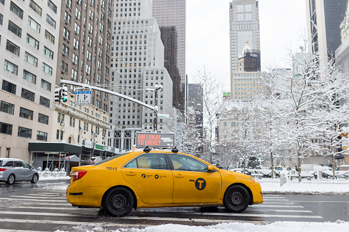 Manhattan, New York City, USA - January, 7.  Yellow taxi on Midtown Manhattan street after huge snowfall in New York City.