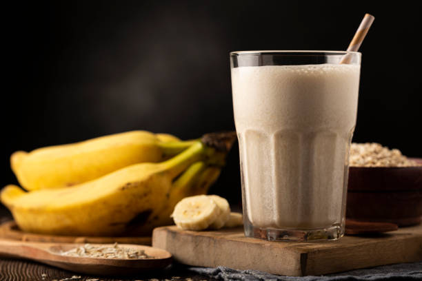 банановый смузи с молоком, бананом и овсянкой. - smoothie banana smoothie milk shake banana стоковые фото и изображения