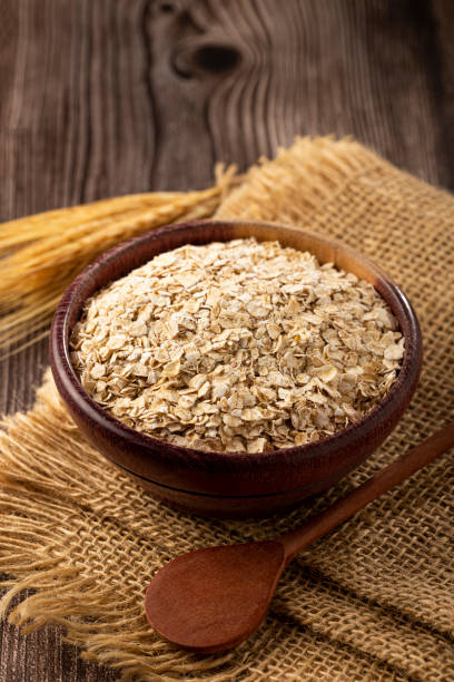 copos de avena en cuenco de madera. - harina de avena fotografías e imágenes de stock