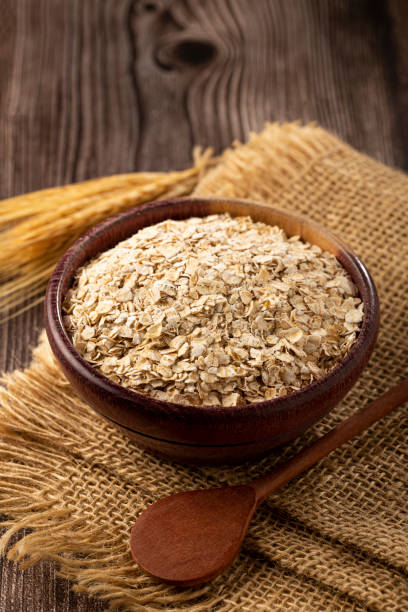 oat flakes in wooden bowl. - oat imagens e fotografias de stock