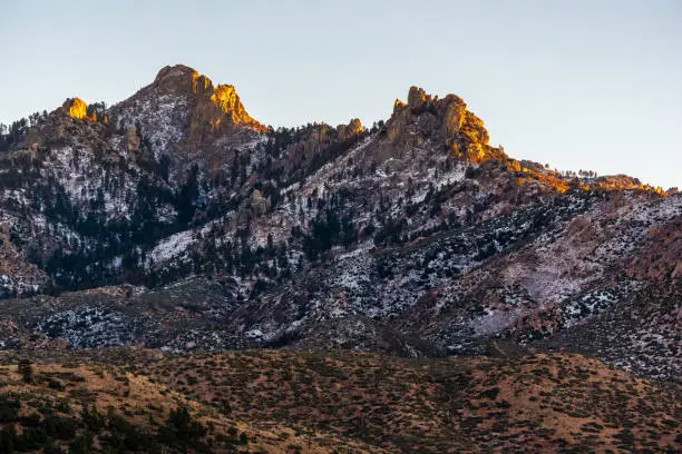 A snowy peak in Hualapai Mountain in Arizona catches the last rays of the setting sun.