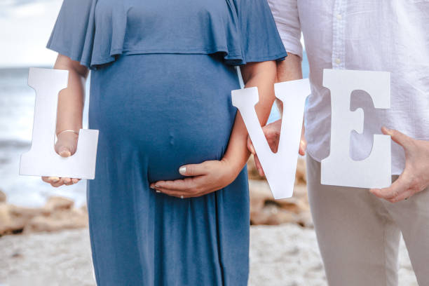 istock Newly Expecting Parents holding Love Sign 1364309239
