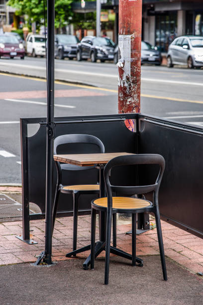 due sedie e un tavolo singolo per mangiare all'aperto in un bar - cafe coffee shop sidewalk cafe menu foto e immagini stock