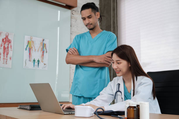 istock Two uniformed young doctors work in medical clinic office. 1364316692